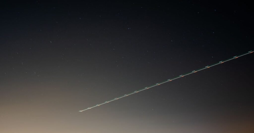 Un cielo nocturno sereno sobre el campo con una estela de luz y estrellas distantes en Madrid, España.