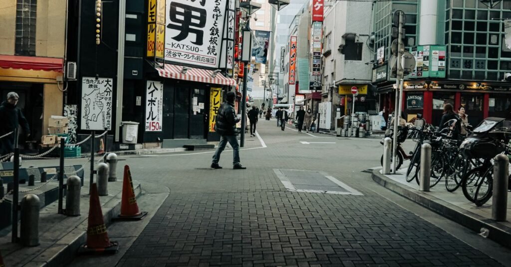 Vista vibrante de la calle en Kioto con gente caminando y una distintiva señalización japonesa.