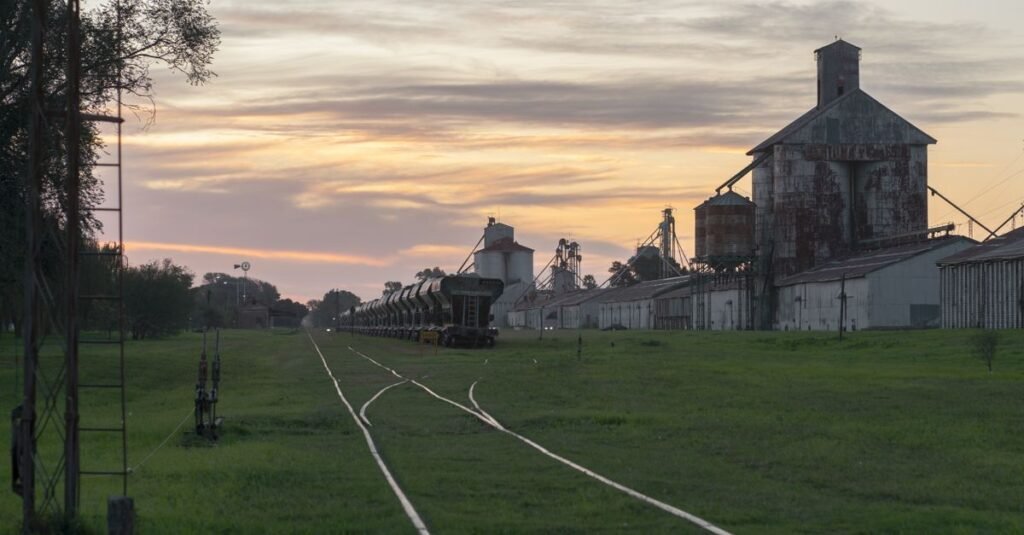 Vista del atardecer de un sereno paisaje ferroviario e industrial en Córdoba, Argentina.