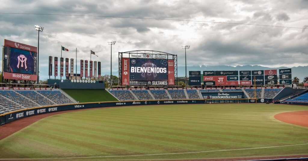 Estadio de béisbol vacío en Monterrey, México, con cartel electrónico de bienvenida.