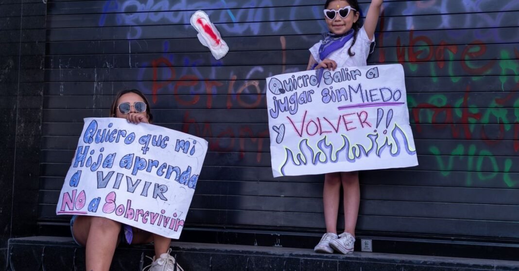 Comerciantes vuelven a bloquear Avenida Juárez por reordenamiento en la Alameda Central Madre e hija sosteniendo carteles de protesta en Ciudad de México, abogando por la seguridad y derechos.