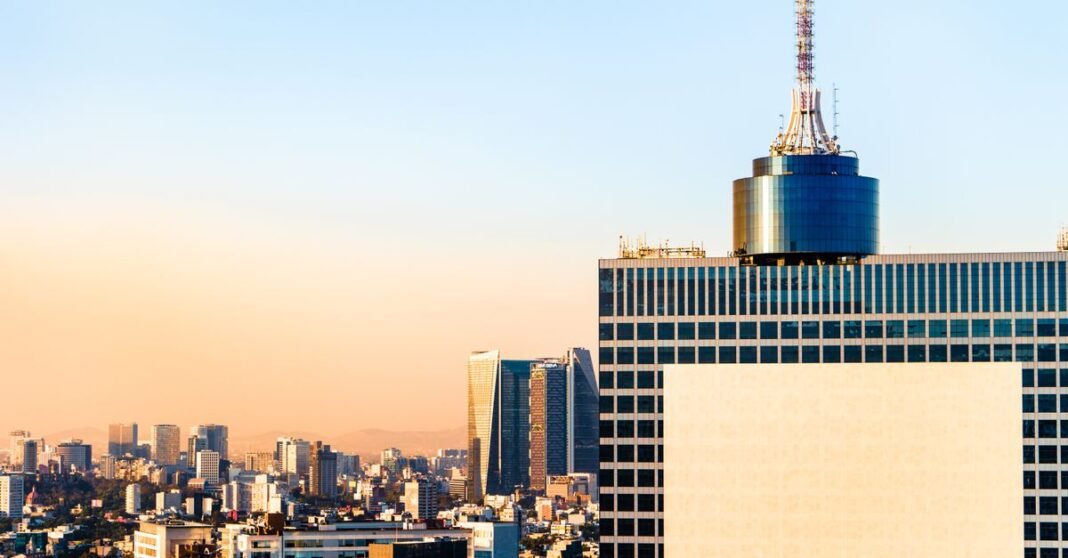 Congreso de la CDMX rechaza la ratificación de Ernestina Godoy como fiscal capitalina Una vista impresionante del horizonte de la Ciudad de México con rascacielos bajo un vibrante cielo de atardecer.