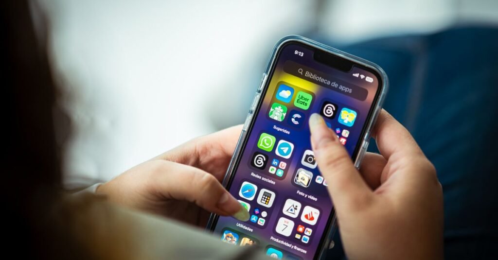 Primer plano de una mujer sosteniendo un teléfono inteligente mostrando varias aplicaciones.