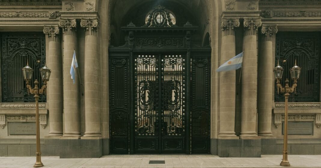 Sheinbaum explica por qué no invitó al rey Felipe VI a su toma de posesión Elegante entrada del Palacio San Martín, Buenos Aires, con puertas ornamentadas y banderas argentinas.