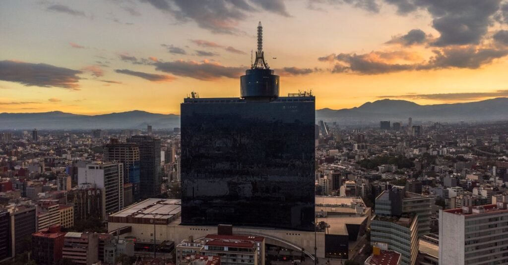 Vista aérea del horizonte de Ciudad de México al atardecer, con techos urbanos y rascacielos impactantes.