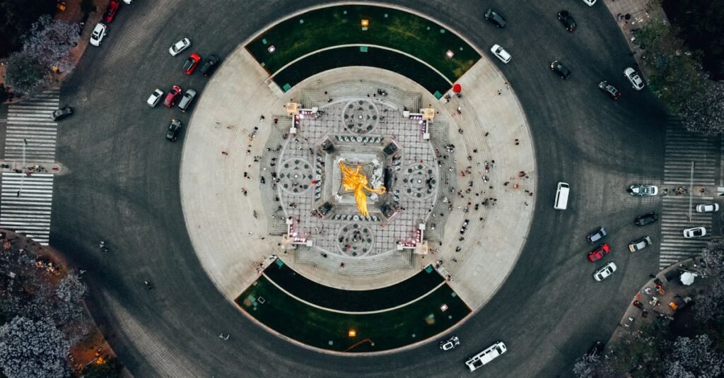 Toma de dron del Ángel de la Independencia en Ciudad de México, capturando la vida urbana y el tráfico vibrante.