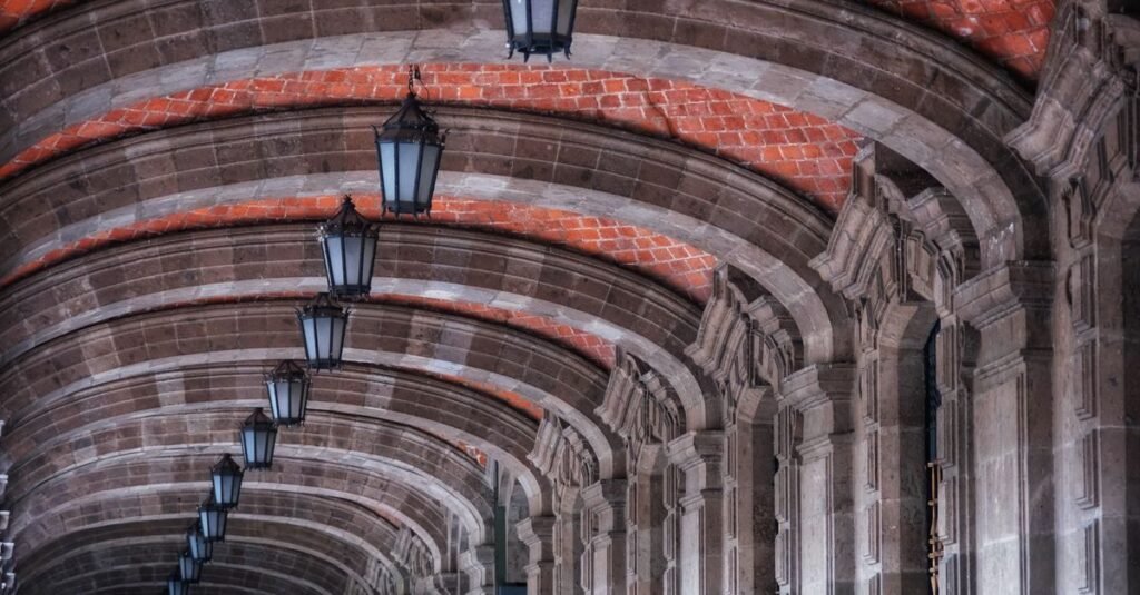 Primer plano del escudo de la Universidad Nacional de México en una pared de ladrillos blancos.