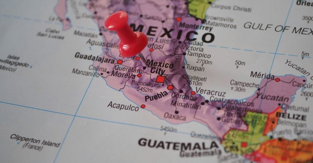 Primer plano detallado de un mapa que presenta a México con un chinche rojo destacando una ubicación.