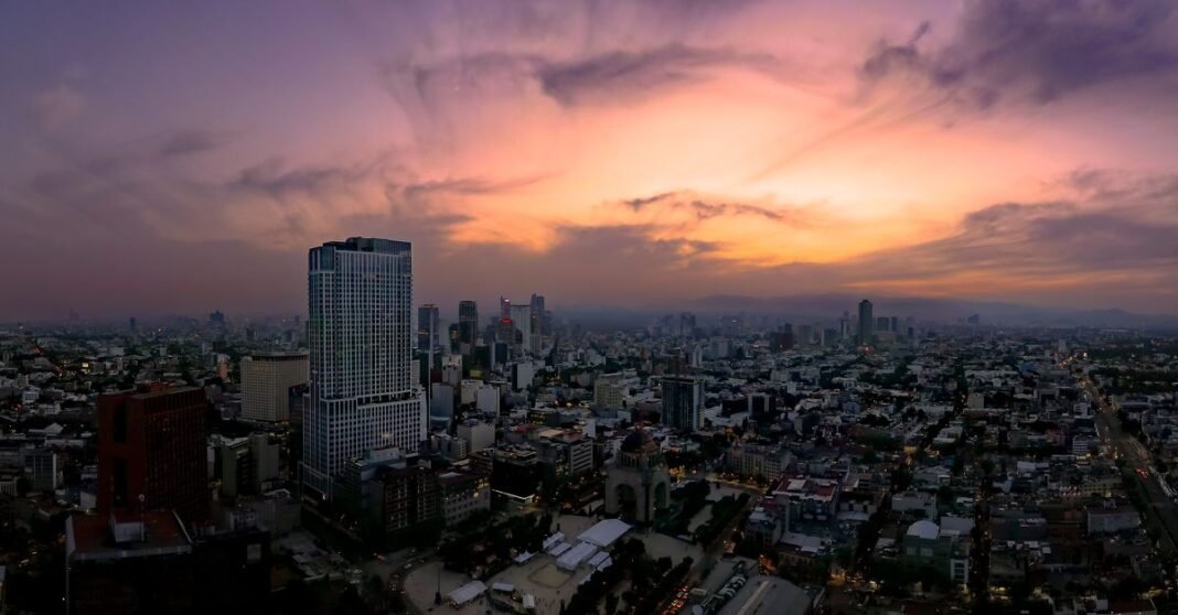 Microsismos en la CDMX: la sobreexplotación del acuífero aparece como una hipótesis, no como causa única Escena de una parada de autobús con edificios coloridos en Ciudad de México, mostrando la vida urbana local.