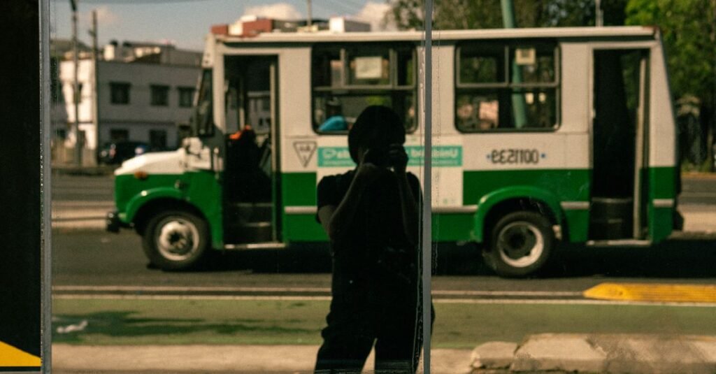 Foto en monocromo de una calle urbana en la Ciudad de México con persianas de tiendas cerradas y juego de sombras.