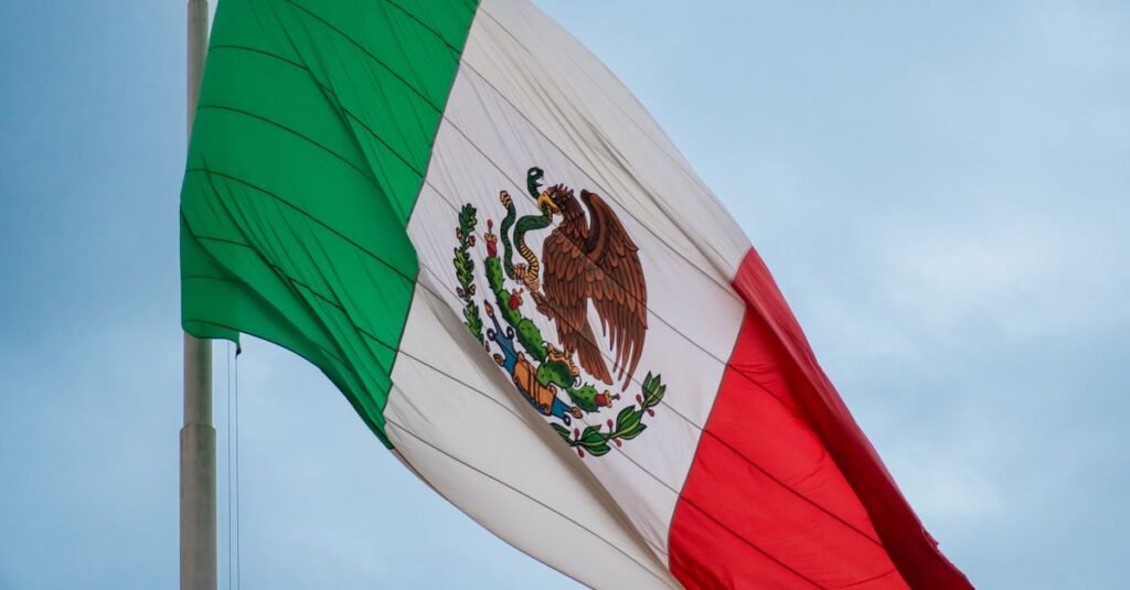 Imagen en alta resolución de la bandera mexicana ondeando al viento, simbolizando el orgullo nacional y la libertad.