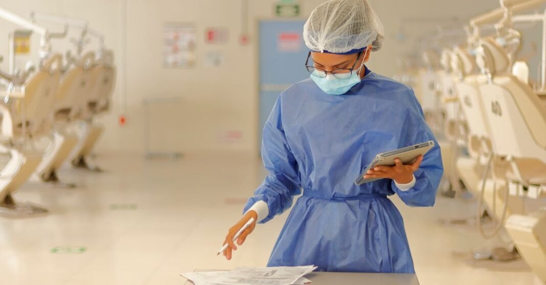 México suma 53 casos confirmados de mpox y la CDMX concentra la mayor parte de los contagios Un profesional de la salud con equipo de protección azul revisa documentos en una clínica médica.