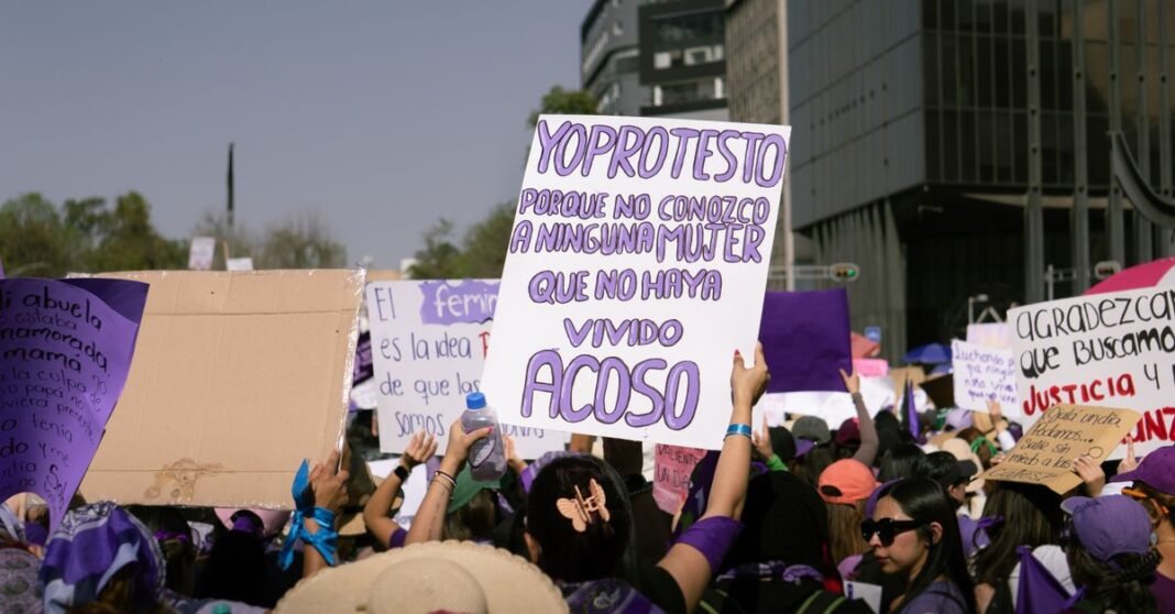 Más participación política, más violencia de género: el reto que persiste para las mujeres en México Protesta callejera enérgica con una multitud diversa y carteles coloridos al aire libre.