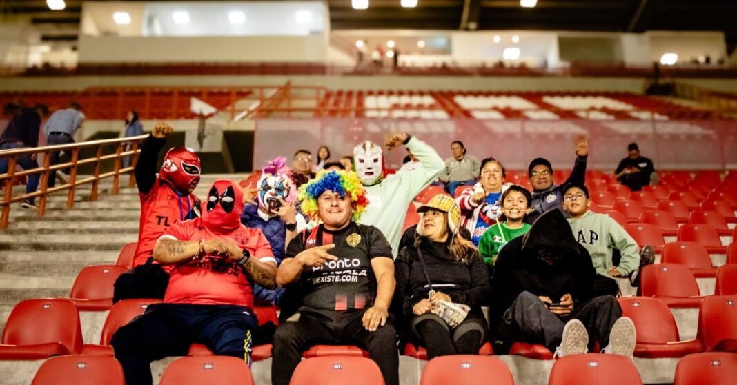 México queda fuera de la Copa América tras empatar con Ecuador y las redes reaccionan con memes Grupo de coloridos fanáticos del fútbol animando en las gradas del estadio por la noche.