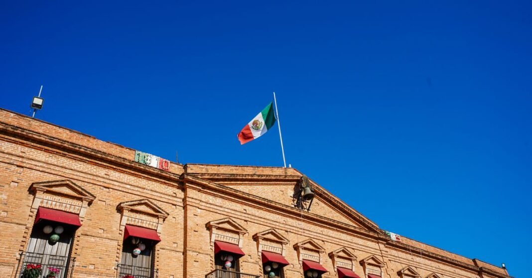 Congreso de Sinaloa designa a Graciela Domínguez Nava como gobernadora interina Edificio histórico en Topolobampo con bandera mexicana contra el cielo azul claro.