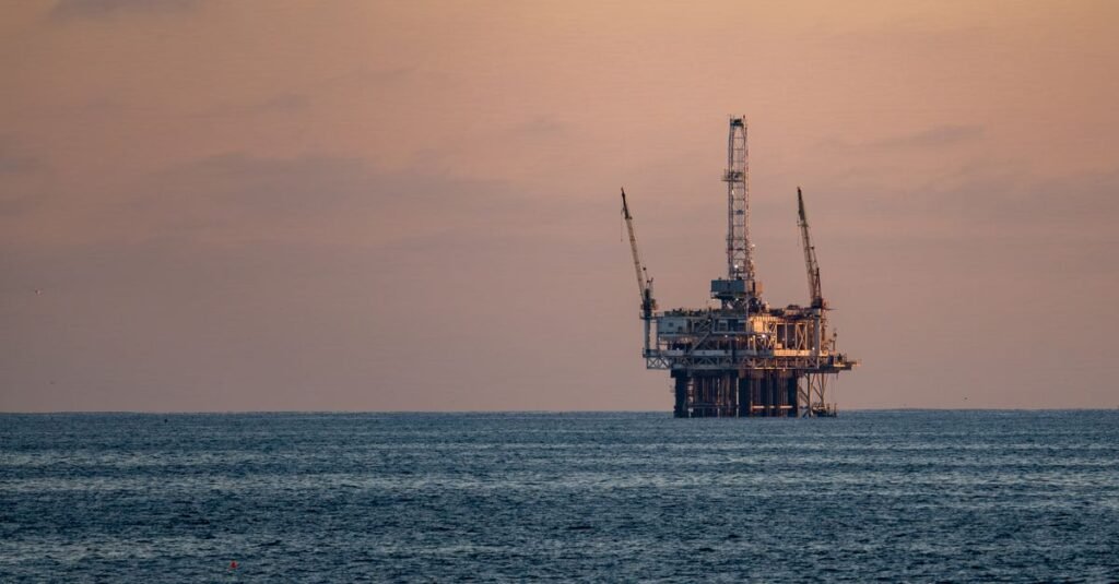 Silueta dramática de una bomba de petróleo contra un vibrante cielo al atardecer, enfatizando la extracción de energía.