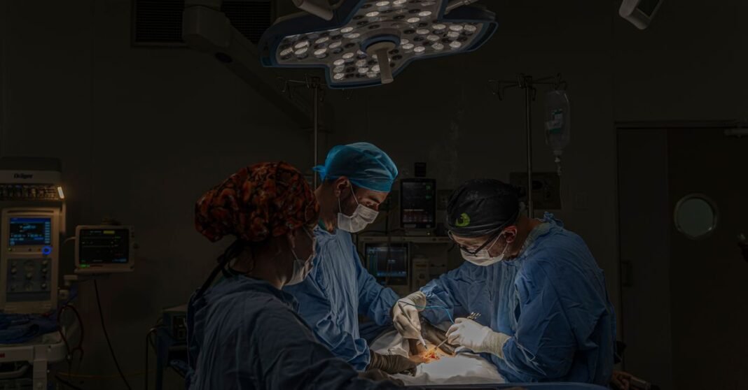 IMSS-Bienestar lanza “Médicas y Médicos del Bienestar” para reforzar la atención en zonas remotas Equipo de cirujanos realizando un procedimiento quirúrgico bajo luces brillantes en un quirófano moderno en México.