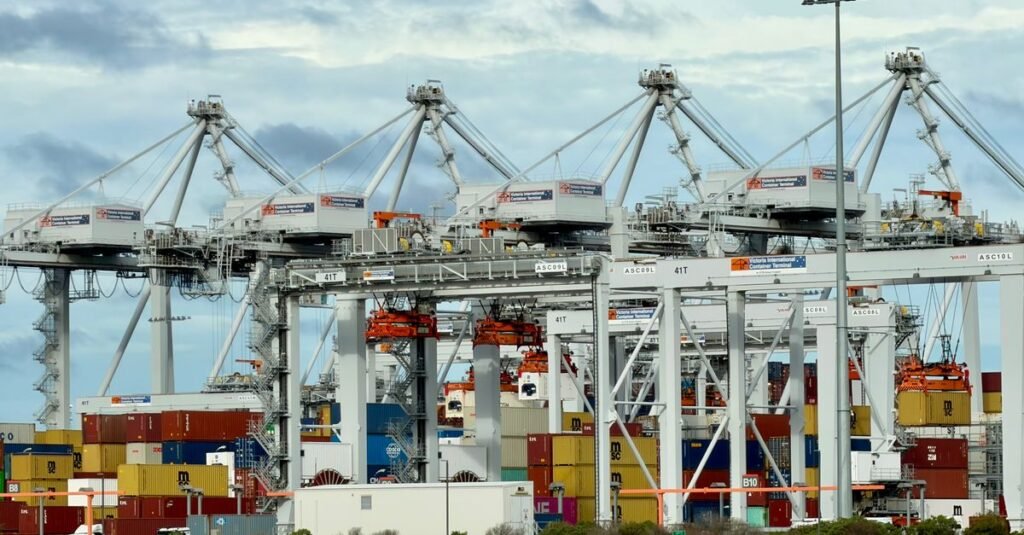 Una bulliciosa terminal de contenedores automatizada en el puerto de Melbourne, donde se pueden observar grúas y contenedores de transporte.