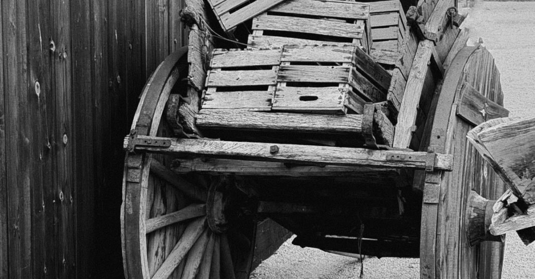 EU fija cuotas preliminares de hasta 5.28% a fresas mexicanas en investigación antidumping Foto en blanco y negro de un viejo carro de madera con cajas, mostrando el encanto rústico.