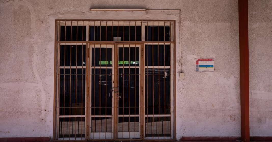 Zoé Robledo recorre unidades médicas de San Felipe y plantea reforzar servicios de IMSS-Bienestar Una verja rústica de hierro en una pared texturizada con un cartel de advertencia, capturada a plena luz del día.