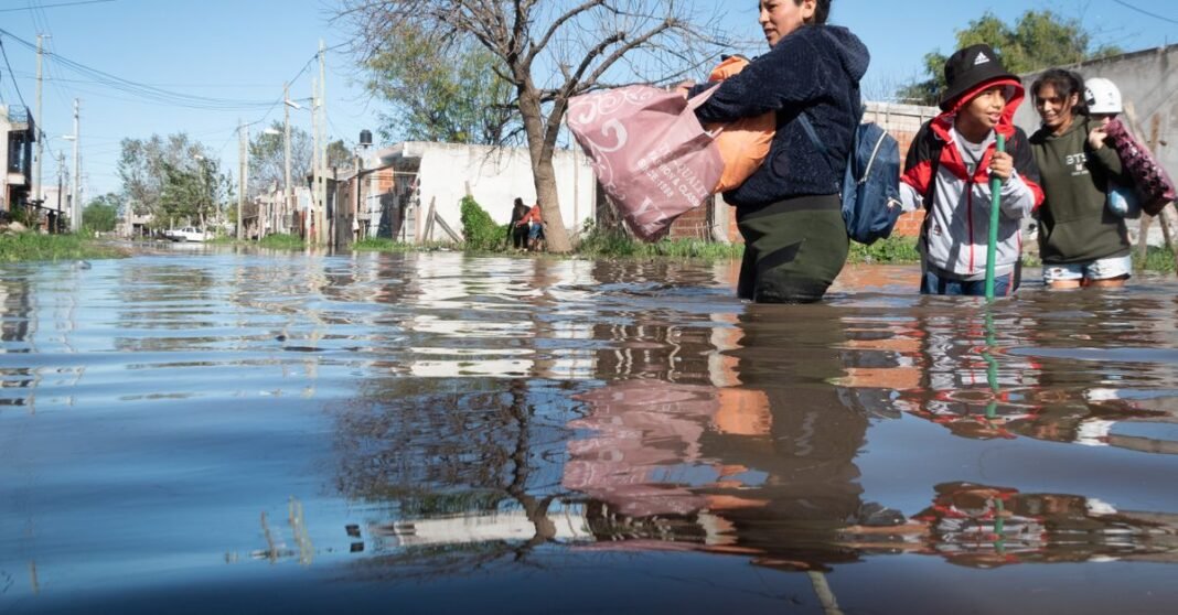 Personas atraviesan calles inundadas en Buenos Aires, Argentina, después de fuertes lluvias.
