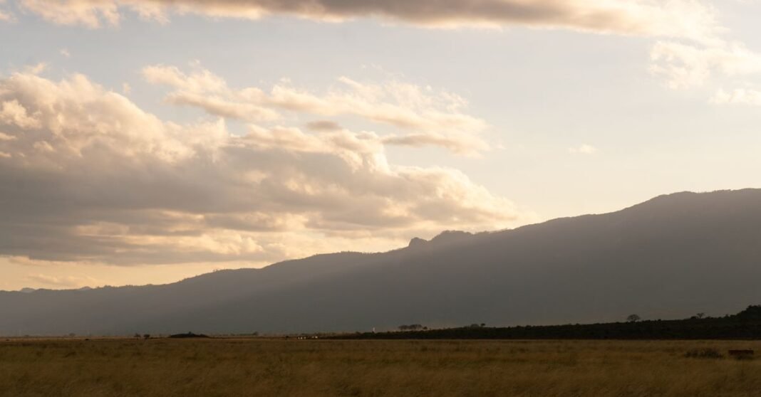 Muere el director de Inteligencia de Ecuador junto con su esposa en accidente de helicóptero en Kenia Una vista apacible de la sabana keniana con montañas pintorescas y cielos nublados al atardecer.