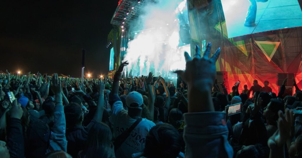 Una multitud jubilosa de aficionados al deporte celebrando al aire libre en un estadio, durante la puesta de sol.