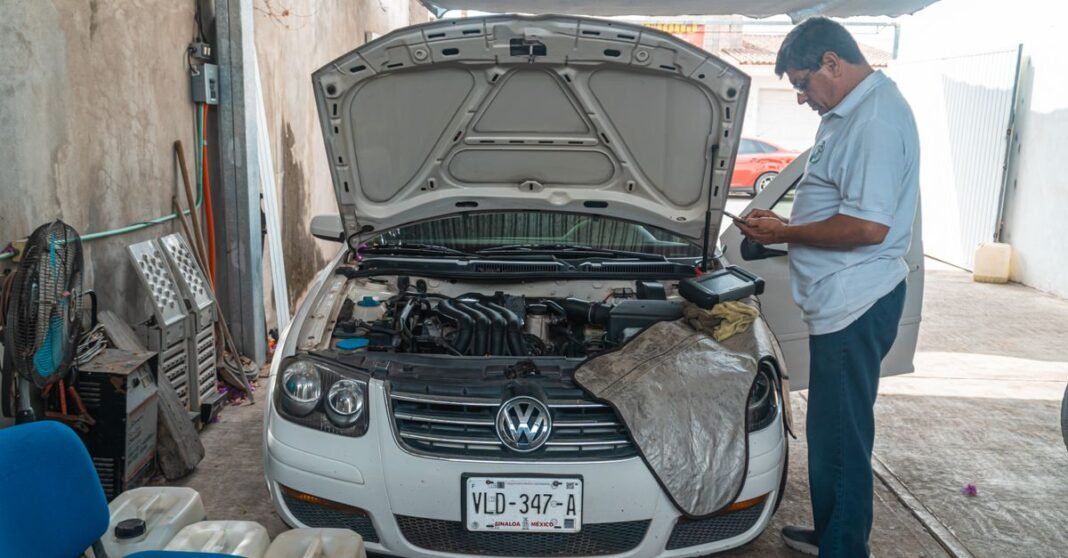 Imagen ilustrativa: Trump impone arancel de 25% a autos importados y enciende alerta en México Un mecánico examina un motor Volkswagen en un entorno de taller, centrándose en el mantenimiento del coche.