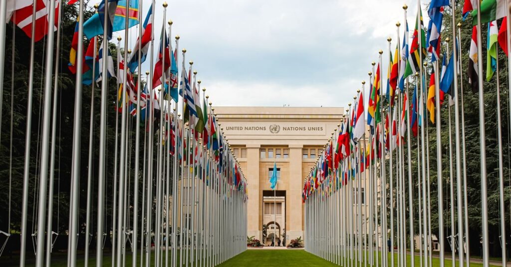La Oficina de las Naciones Unidas en Ginebra rodeada de banderas internacionales que simbolizan la unidad global.