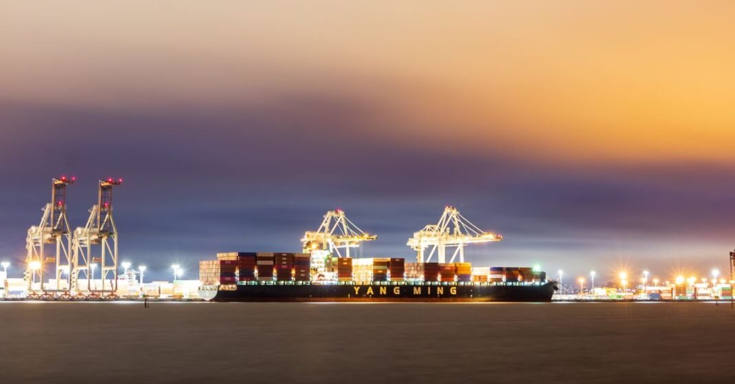 México envió ayuda humanitaria a Venezuela; cifra de 718 toneladas no coincide con registros oficiales Un barco de carga atracado en el puerto de Oakland al atardecer, con cielos vibrantes y grúas industriales.