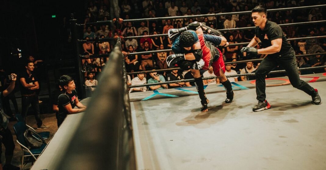 Ataque e incendio en el CUM de Hermosillo obligan a suspender función de boxeo e influencers Dos atletas en combate dinámico durante una pelea de artes marciales mixtas.