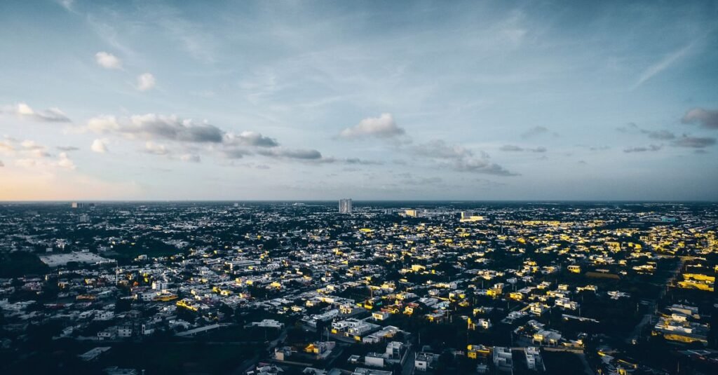 Una vibrante vista aérea de Mérida, México, que muestra el extenso paisaje urbano de la ciudad bajo un cielo de atardecer.