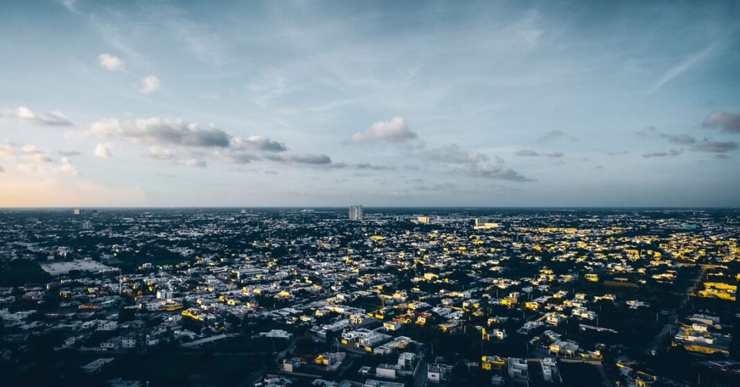 Alertan por riesgo de conflictos sociales ante la escasez de agua en México Una vibrante vista aérea de Mérida, México, que muestra el extenso paisaje urbano de la ciudad bajo un cielo de atardecer.