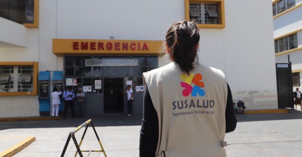 Un profesional de la salud con equipo de protección azul revisa documentos en una clínica médica.