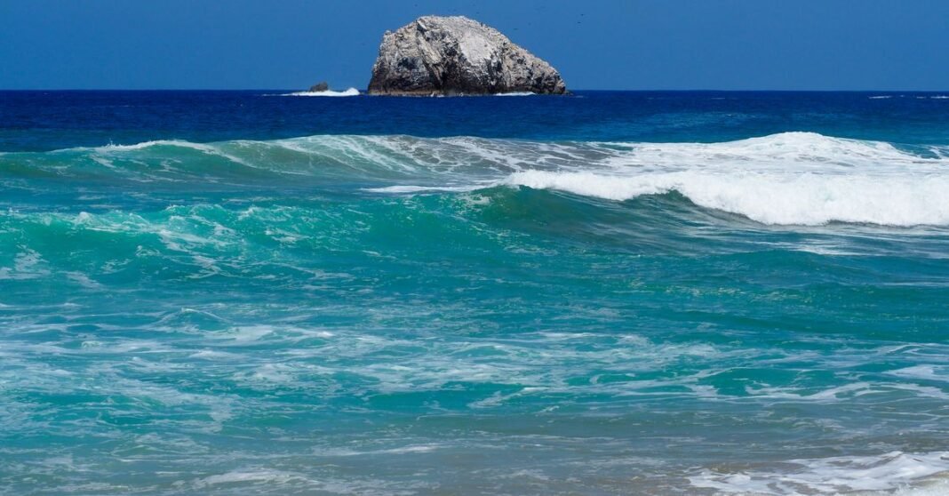 Tormenta tropical Marie se fortalecería en el Pacífico; no había pronóstico de impacto directo en México Olas dinámicas del océano rompiendo contra rocas costeras en Ensenada, México, bajo un brillante cielo de verano.