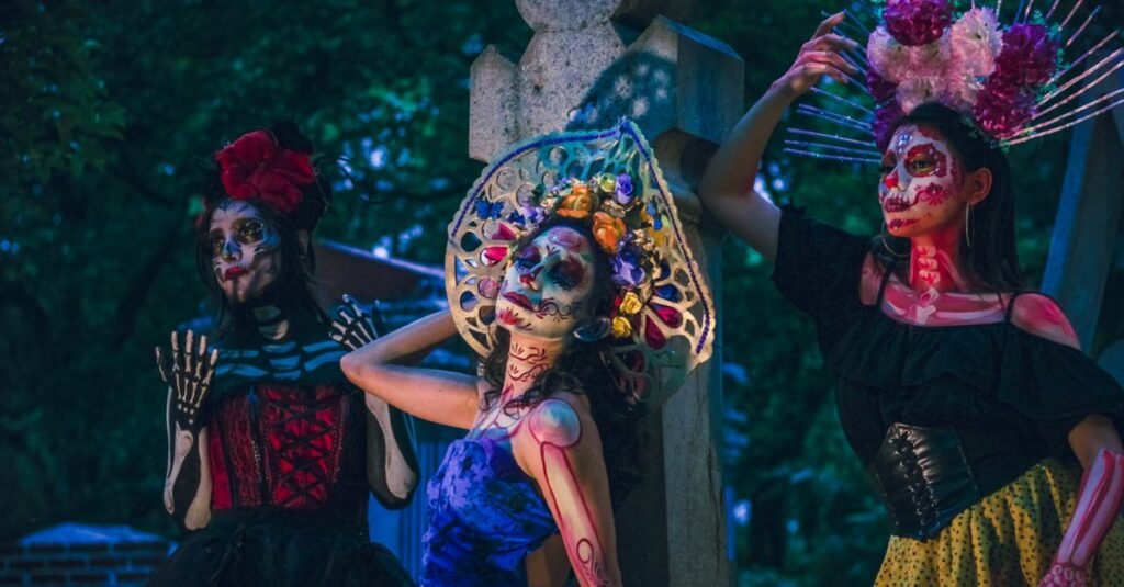 Vibrante celebración del Día de los Muertos con mujeres en atuendos tradicionales de Catrina por la noche.