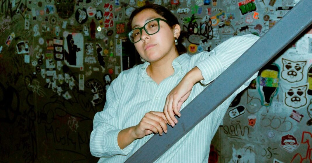 Mujer con gafas posando en un entorno urbano de grafiti, Ciudad de México.