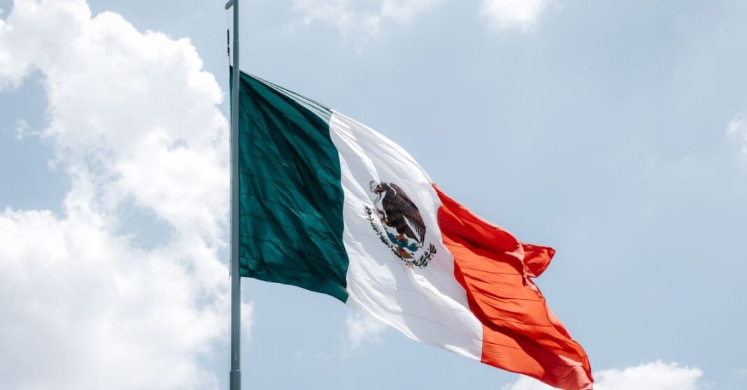 Ebrard ve como una señal alentadora el arranque de las conversaciones técnicas para revisar el T-MEC con Estados Unidos La bandera mexicana ondea majestosamente contra un claro cielo azul en Ciudad de México, México.