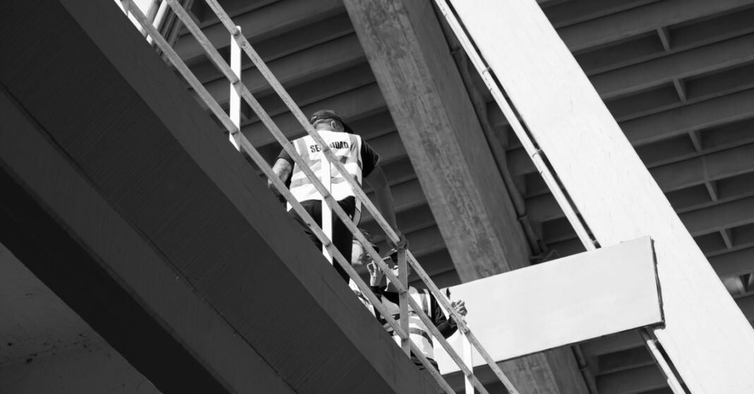 Fotografía en blanco y negro de las tribunas vacías de un estadio de Córdoba, resaltando la estructura y la atmósfera.