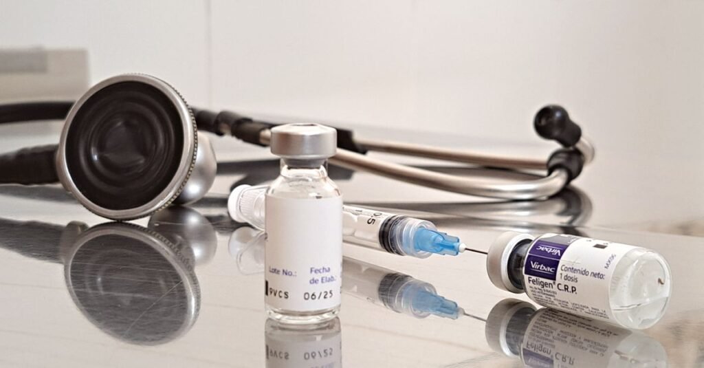 Primer plano de un trabajador de la salud llenando una jeringa desde un vial, demostrando vacunación o procedimiento médico.
