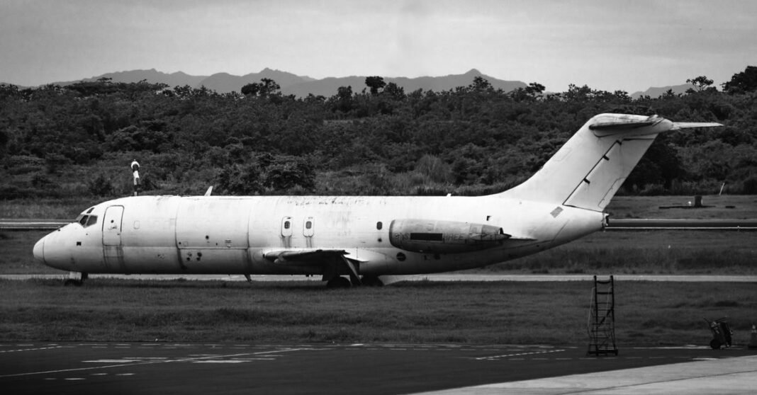Imagen ilustrativa: Avión de carga de Amazon se sale de pista en Miami; cinco personas murieron en vehículos alcanzados Imagen en blanco y negro de un avión antiguo en el aeropuerto de Tocumen, Panamá, con una persona cerca.