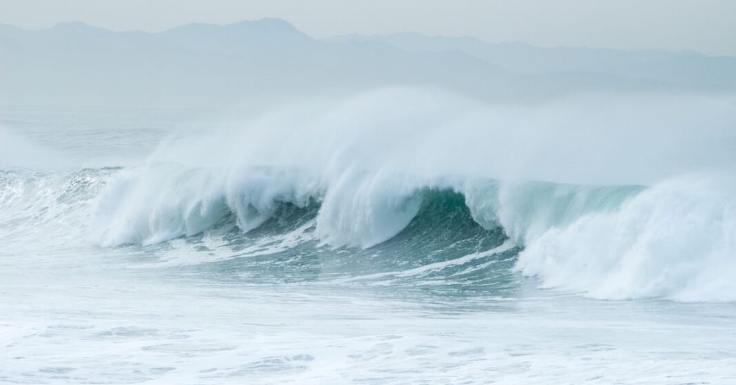 Huracán Polo baja a categoría 4; pronósticos difieren sobre su posible llegada a Baja California Sur Una impresionante vista aérea de las olas rompiendo en la costa de Playa del Carmen, México, mostrando la belleza natural.