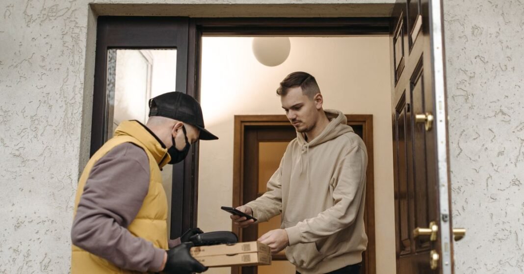 Amazon Prime aumenta su precio en México: la mensualidad sube a 129 pesos y el plan anual a 945 Un hombre recibe pizza de un mensajero con mascarilla, asegurando una entrega sin contacto en casa.